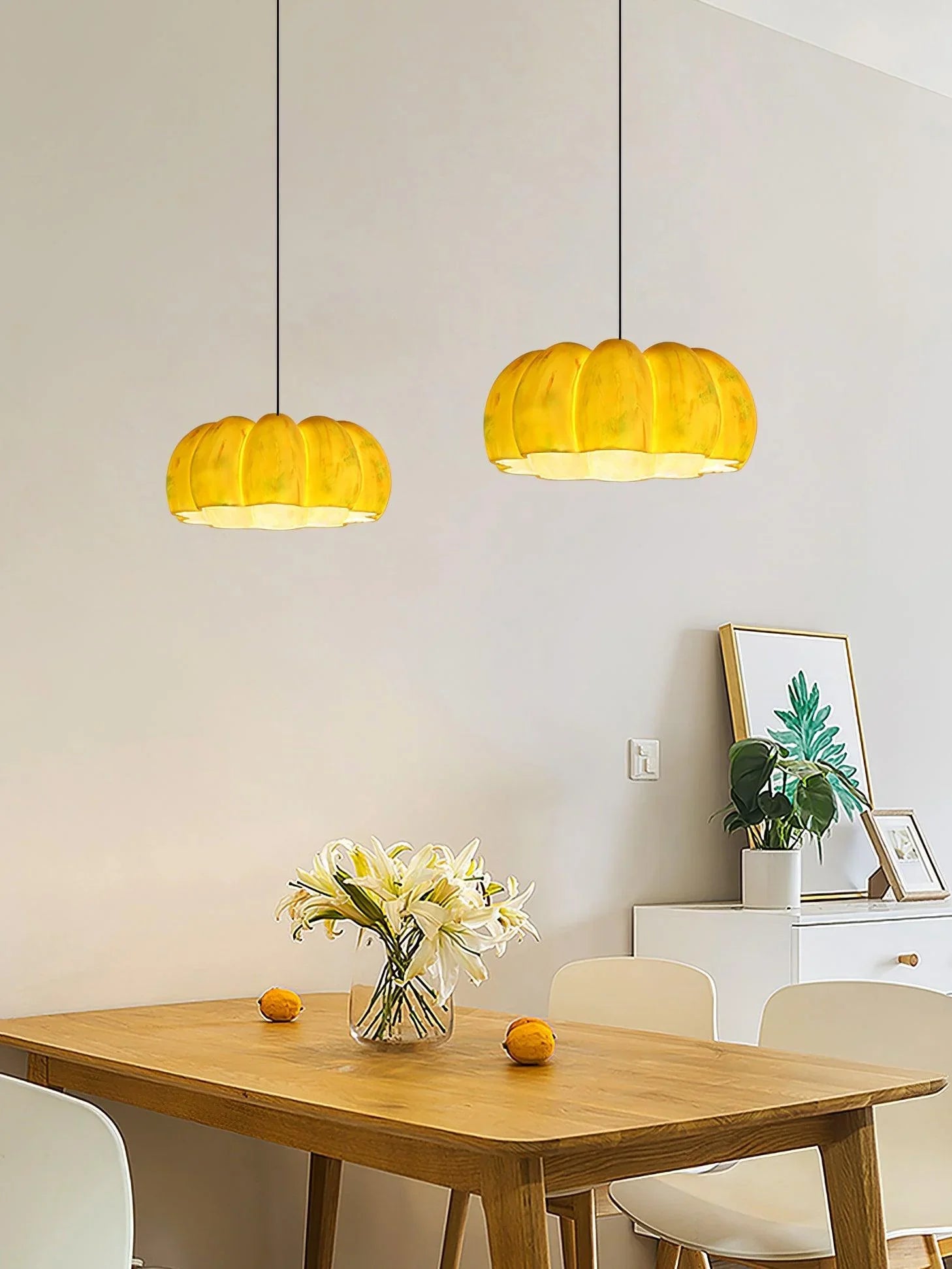 Yellow pumpkin pendant lights above a modern dining table with flowers, YH Lamps chandelier