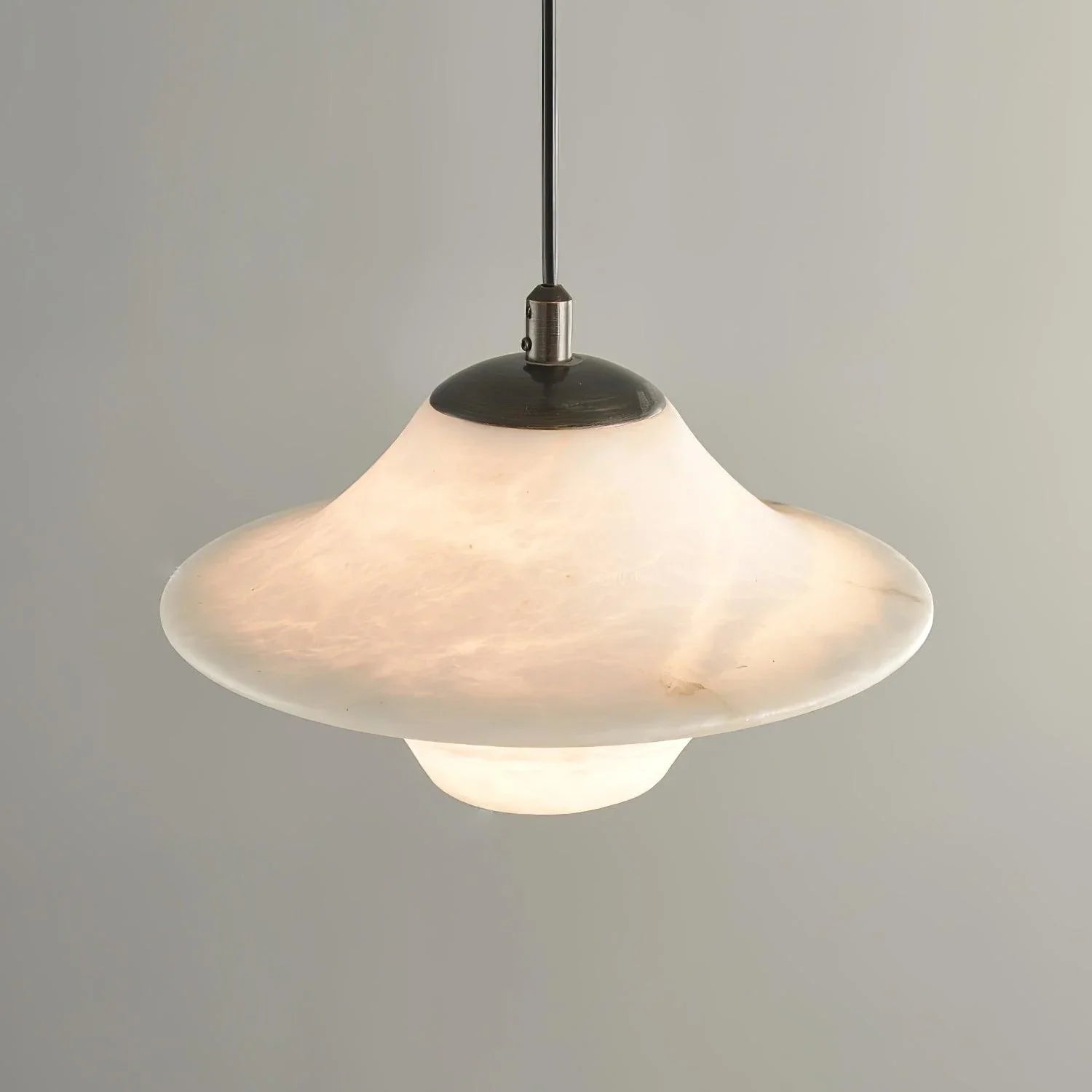 Modern alabaster pendant lamp with black metal fixture, saucer-shaped shade, soft diffused light