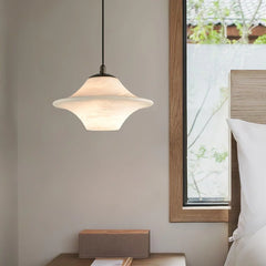 Modern alabaster pendant lamp with saucer shape hanging above wooden bedside table near window in cozy bedroom