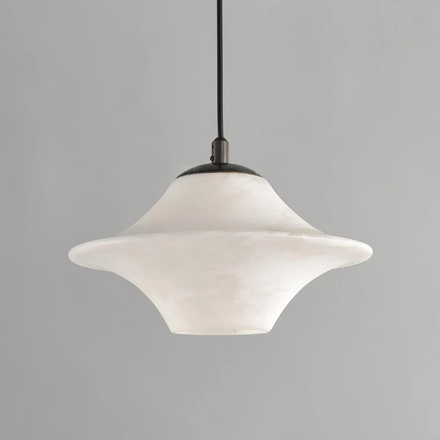 Modern alabaster pendant light with black metal fixture, suspended against gray background
