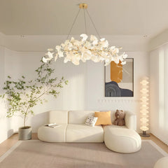 Modern living room with white ginkgo chandelier pendant lamp, beige sectional sofa, floor lamp, and abstract wall art