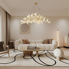 Modern living room with white textured sofa, wooden coffee table, abstract rug, and a decorative gingko gold and white pendant chandelier