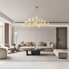 Modern living room with beige sofa, dark wood coffee table, and artistic gold-white ginkgo chandelier pendant lamp