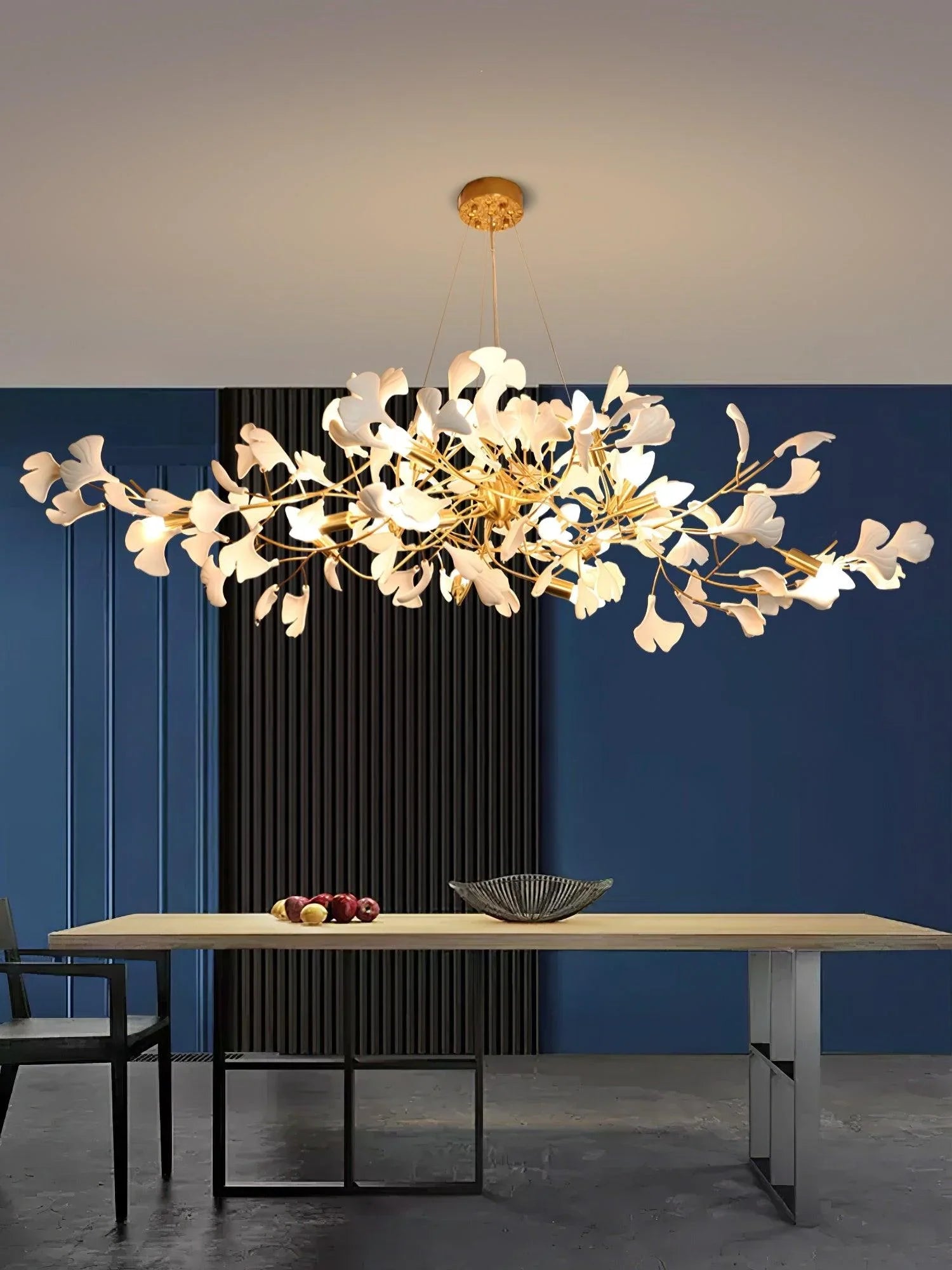 Modern gold and white ginkgo leaf chandelier pendant lamp over wooden dining table in contemporary room