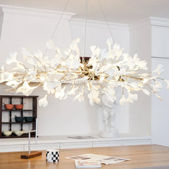 Modern white and gold ginkgo leaf chandelier pendant lamp hanging in bright dining room