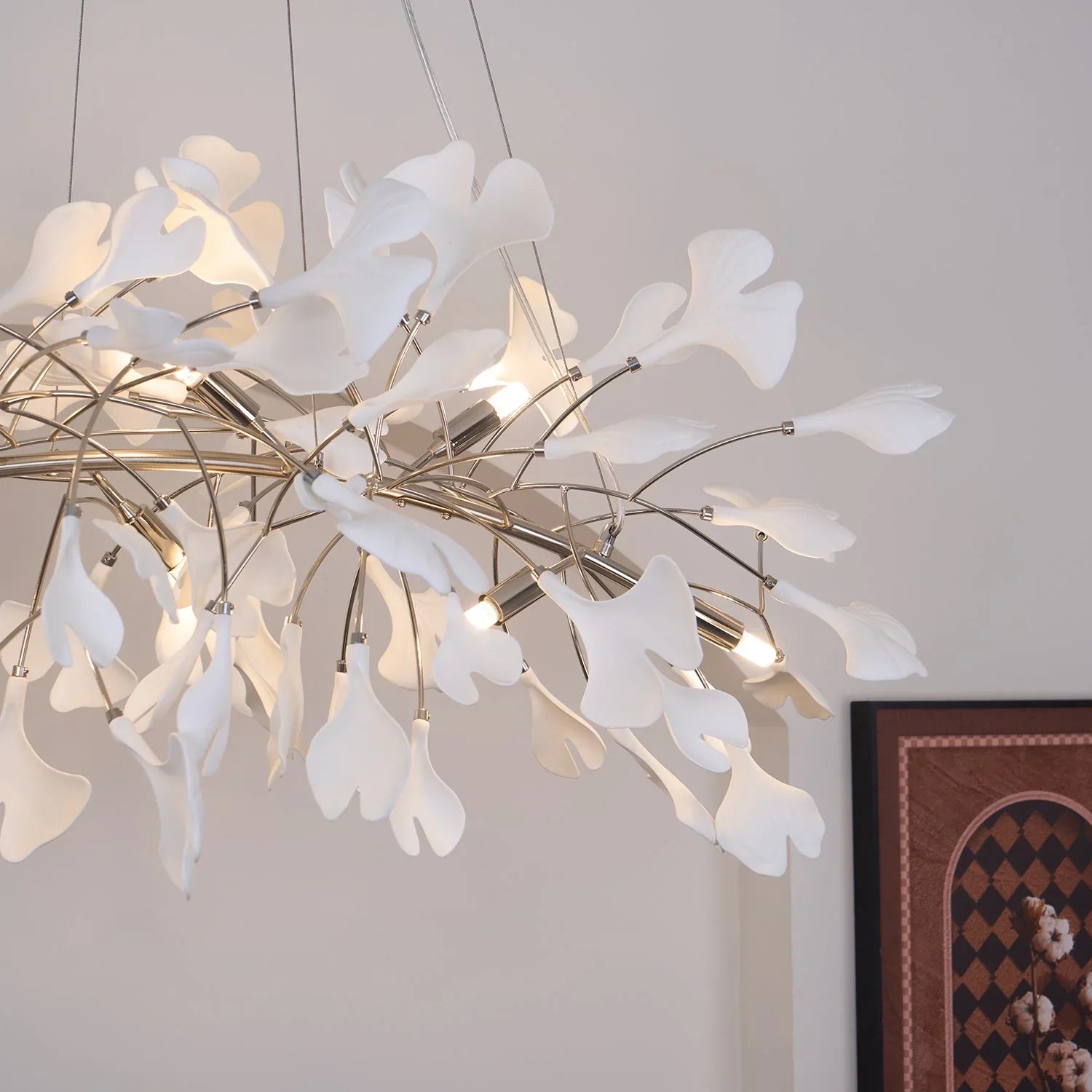 Modern gold and white Gingko chandelier pendant lamp with delicate leaf-shaped shades in a minimalist room