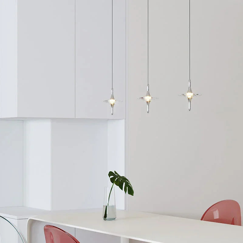 Modern crystal pendant lamps from YH Lamps above a white dining table in a minimalist room