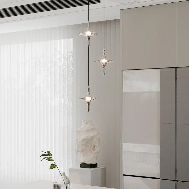 Modern crystal pendant chandelier with three hanging lights in a minimalist dining room