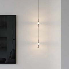 Modern crystal pendant chandelier with sand black and blue accents by YH Lamps, lit on white wall.