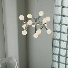 Modern silver space-age chandelier with 10 globe bulbs in a minimalist interior setting