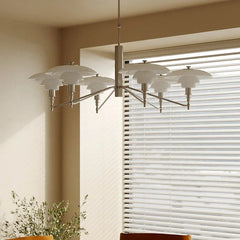 Modern silver designer chandelier with layered white shades in a bright dining room