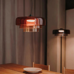 Modern smoke grey pendant lamp with warm light above wooden dining table and chair in cozy room