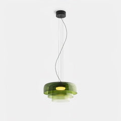 Modern green glass pendant lamp with layered design and warm light, suspended by black cords