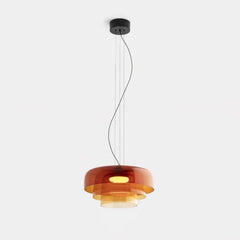 Modern amber glass pendant chandelier with layered circular shades hanging from black ceiling mount