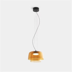 Modern amber glass pendant lamp with layered design and warm white light, suspended by black ceiling mount