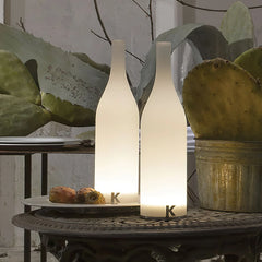 Modern white bottle-shaped table lamps with warm light on decorative outdoor table, YH Lamps
