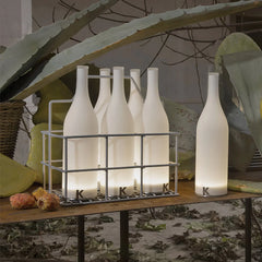 Modern bottle-shaped white table lamps with warm light by YH Lamps on a rustic table.