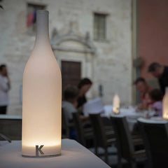Modern white table lamp with bottle shape and warm light on a dining table, YH Lamps