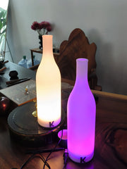 Modern bottle-shaped touch table lamps with warm white and purple light on a wooden desk, YH Lamps