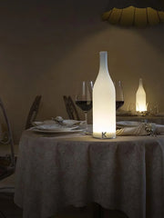 Modern white bottle-shaped table lamp with warm light on a decorated dining table from YH Lamps