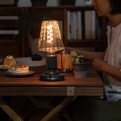 Modern black USB table lamp with glass shade on wooden table, warm glow, home setting