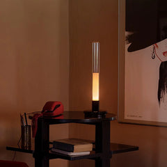 Modern black and clear column table lamp with warm light on a side table, YH Lamps