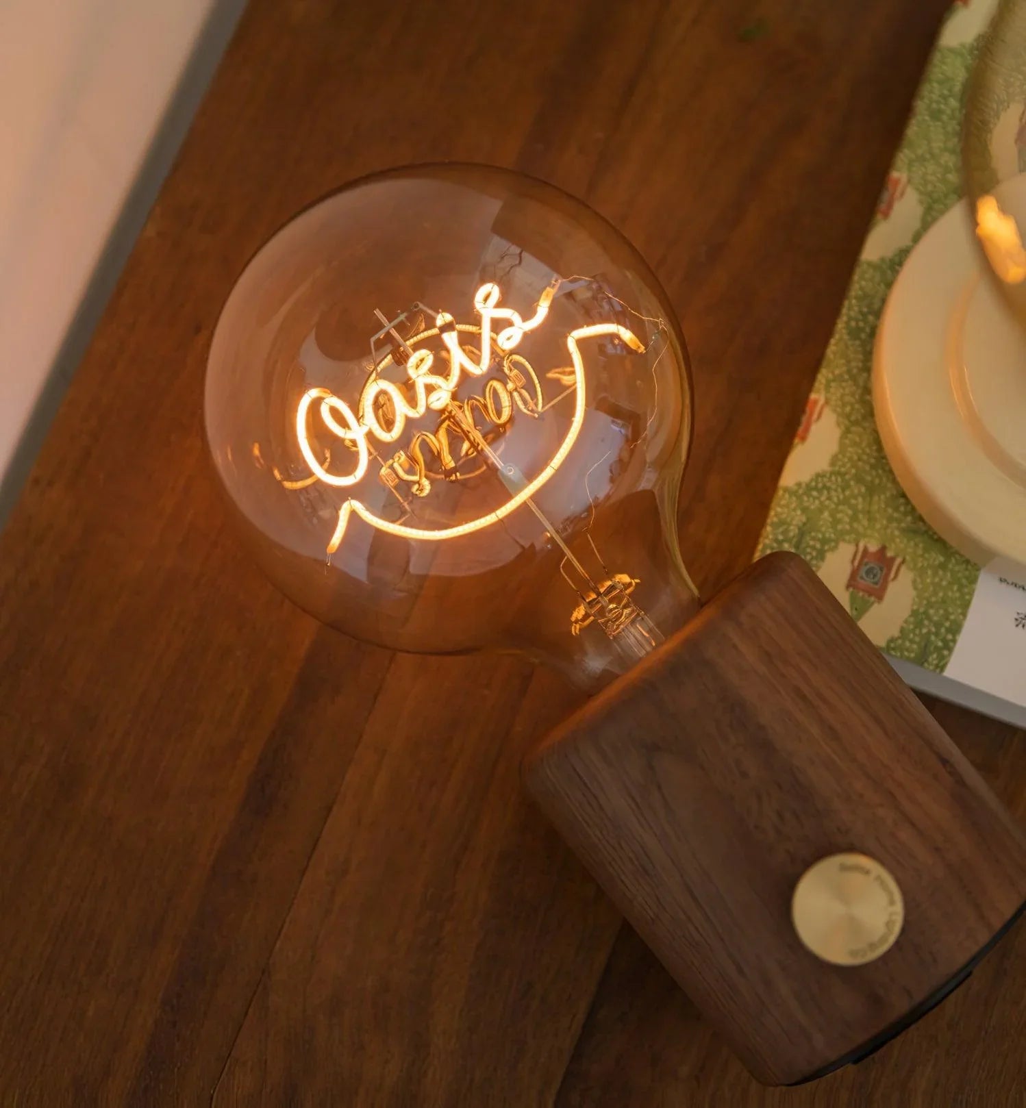 Modern walnut table lamp with glowing bulb, USB charging, on wooden surface by YH Lamps