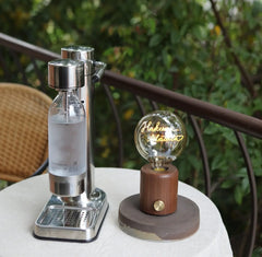 Modern walnut table lamp with round glass bulb and USB base on outdoor table, YH Lamps