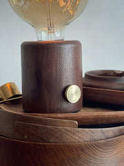 Modern walnut table lamp with exposed bulb and brass knob on wooden surface, YH Lamps