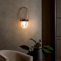 Modern wall sconce with glass shade by YH Lamps, illuminating a stylish living room corner.