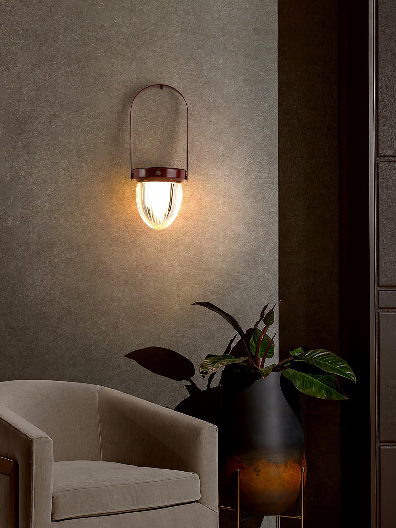 Modern wall sconce with warm light above beige armchair and plant, YH Lamps lighting decor