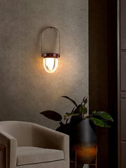 Modern wall sconce with warm light above beige armchair and plant, YH Lamps lighting decor