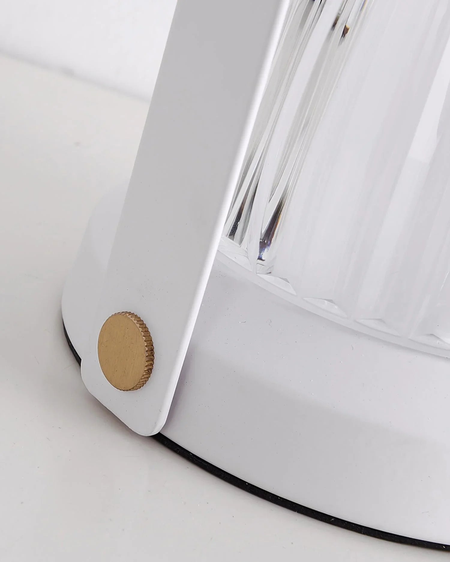 Close-up of a modern white table lamp base with a gold accent and clear textured glass, YH Lamps