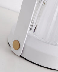 Close-up of a modern white table lamp base with a gold accent and clear textured glass, YH Lamps