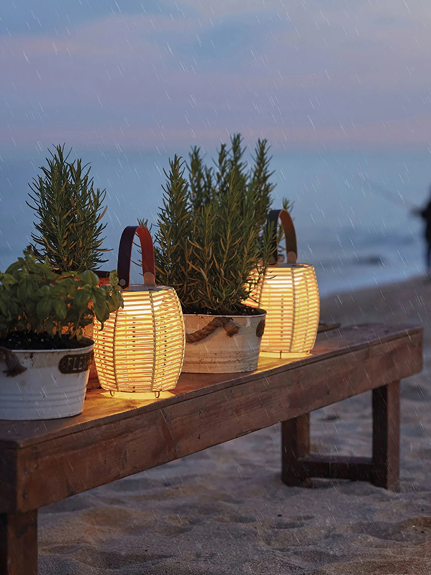 Yellow and white USB lantern table lamps from YH Lamps on a wooden bench by the beach at dusk