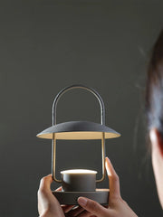 Modern dark gray portable table lamp with touch switch, built-in battery, held by hands