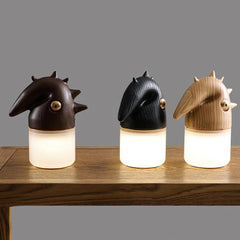 Three modern wooden table lamps with bird-shaped tops and warm light on a wooden surface