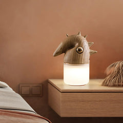 Modern wood color table lamp with dinosaur-shaped design and warm light on bedside table, YH Lamps