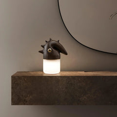 Modern table lamp with wood-color sculpted head and warm light on a stone shelf by YH Lamps