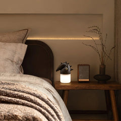 Modern wooden table lamp with unique black animal-shaped top, glowing on bedside table in cozy bedroom, YH Lamps