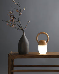Modern wooden Zen table lamp with warm light beside a vase on a minimalist wood table, YH Lamps
