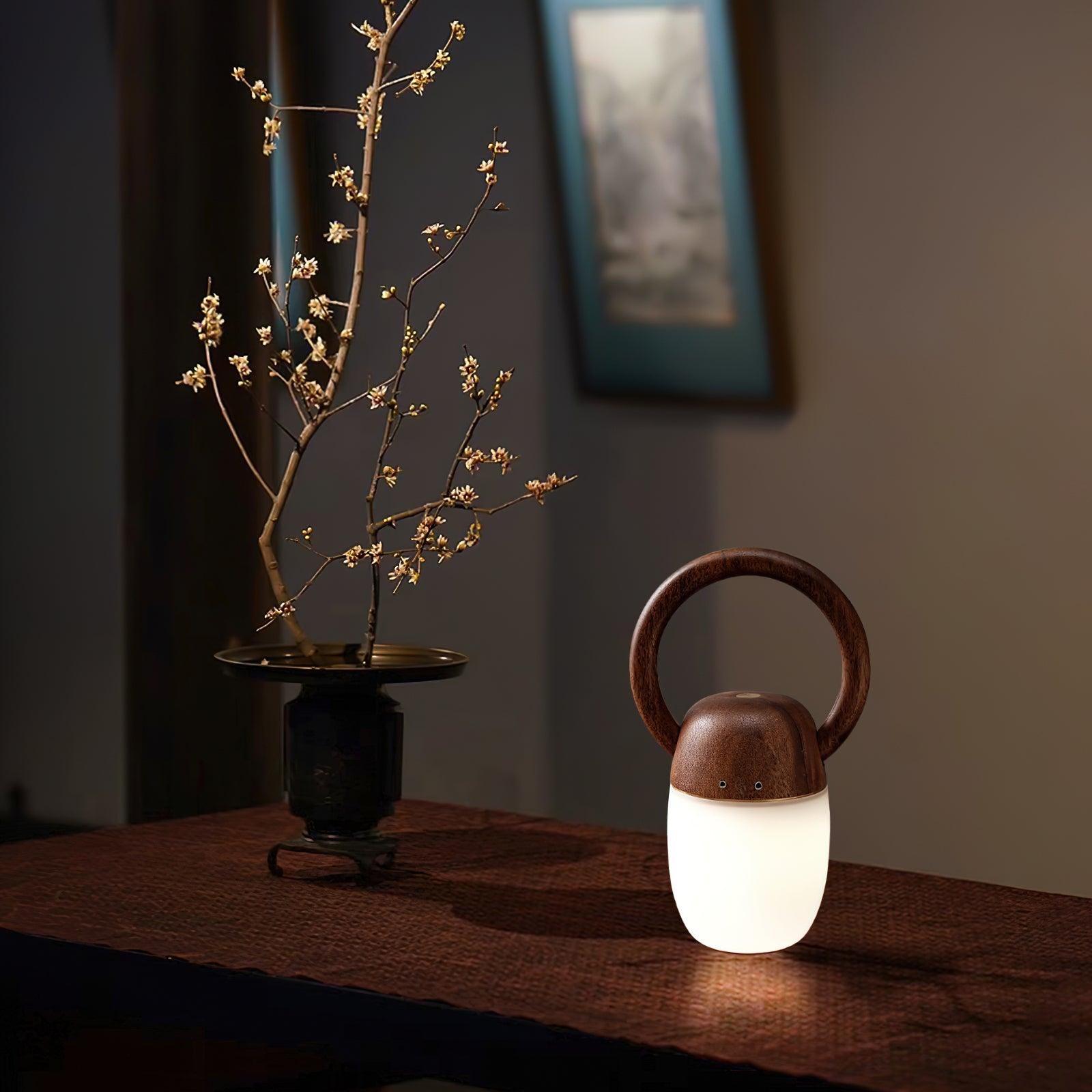 Zen Buddha table lamp with wooden handle and warm light on a brown table, YH Lamps