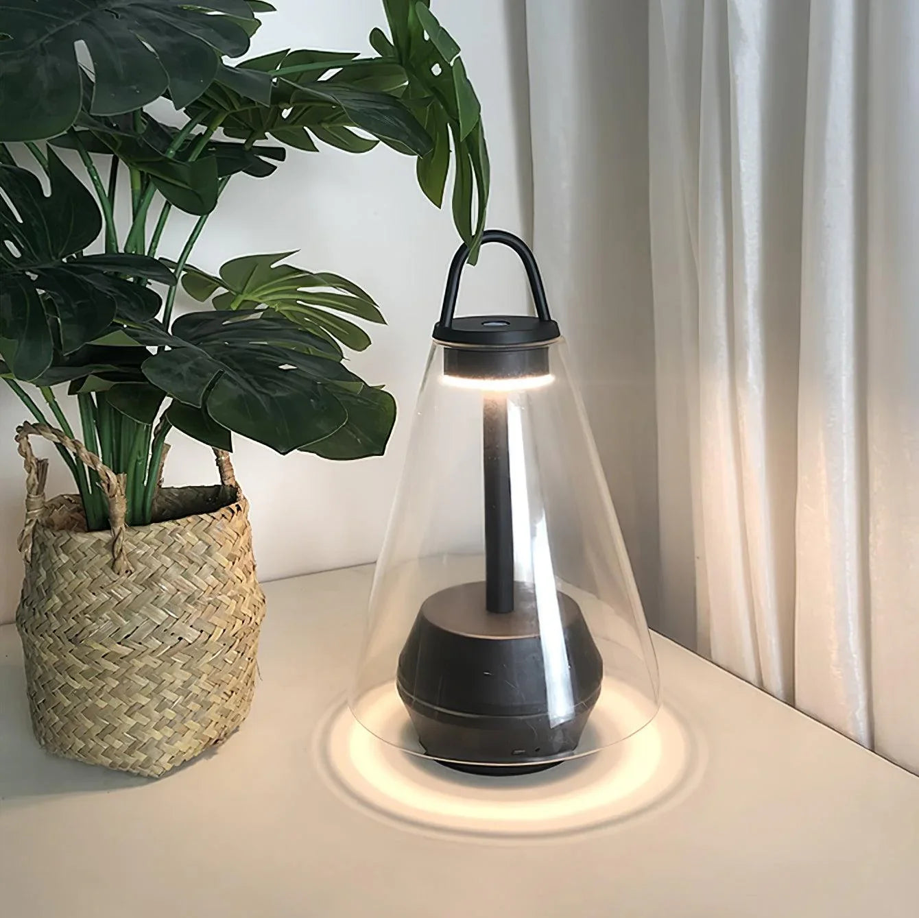 Modern black and clear table lamp with built-in battery on desk beside potted plant, YH Lamps
