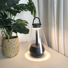 Modern black and clear table lamp with built-in battery on desk beside potted plant, YH Lamps