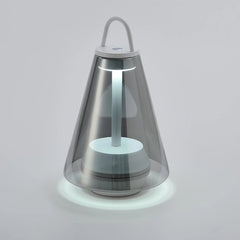 Modern black and clear table lamp with cone shape and handle, lit on a white surface, YH Lamps