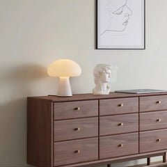 Modern white mushroom table lamp on wooden dresser, next to bust sculpture and laptop, at YH Lamps