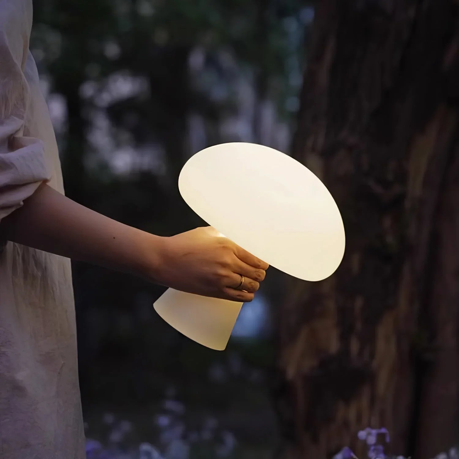 Person holding modern white mushroom-shaped portable table lamp outdoors, YH Lamps