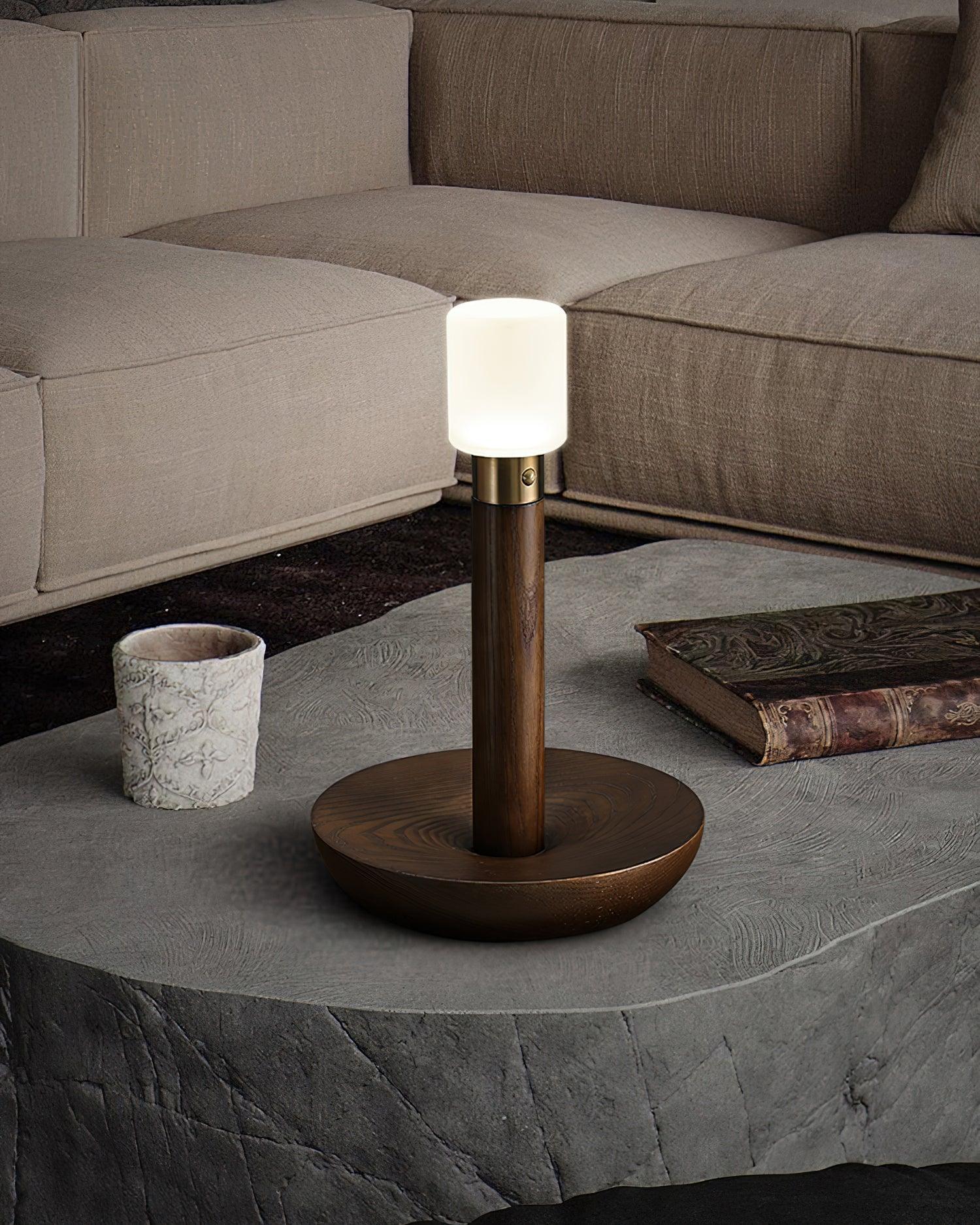 Modern wood and brass table lamp with frosted glass shade on stone coffee table in cozy living room