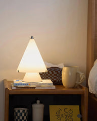Modern white table lamp with cone shade on bedside table, books and mug, YH Lamps