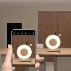 Modern round touch switch table lamp on wooden table, shown via smartphone at YH Lamps